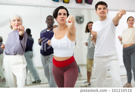 Hispanic woman practicing punches during group self defense course 101210518