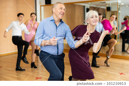 Happy older couple performing a paired ballroom dance in ballroom Happy older couple performing a paired ballroom dance in ballroom 101210913