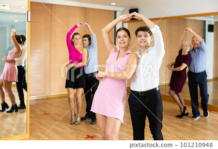 Young couple enjoying impassioned merengue in latin dance class 101210948