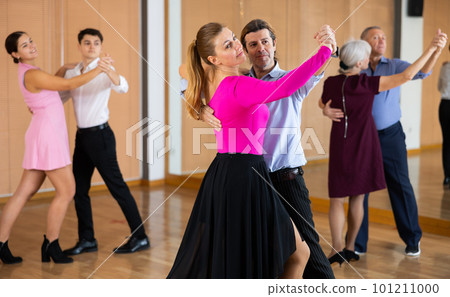 Happy couple performing a paired dance in ballroom 101211000
