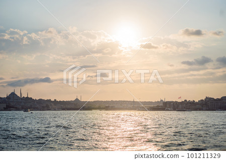 Istanbul at sunset, Turkey. Tourist boat sails on Golden Horn in summer. Beautiful sunny view of Istanbul waterfront with old mosque. Concept of travel, tourism and vacation in Istanbul and Turkey 101211329