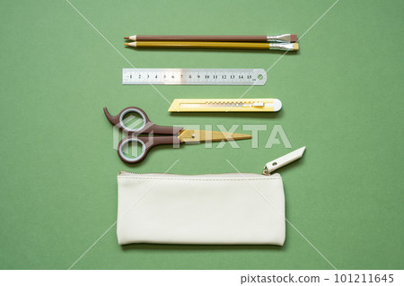 School office writing supplies and pencil case on green desk. top view, copy space 101211645