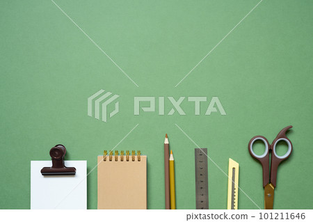 Workspace concept. notepad and writing supplies on green desk. flat lay, top view, copy space 101211646