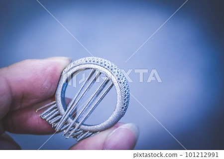 Man is holding object printed on metal 3d printer. Object printed in laser sintering machine. Modern 3D printer printing from metal powder. Progressive additive DMLS, SLM, SLS 3d printing technology Man is holding object printed on metal 3d printer. Object printed in laser sintering machine. Modern 3D printer printing from metal powder. Progressive additive DMLS, SLM, SLS 3d printing technology 101212991