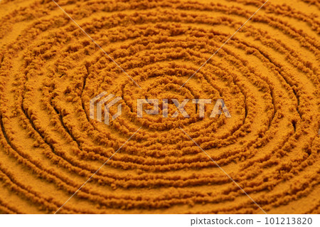 Spiral poured turmeric powder spice background. Dry seasoning turmeric. Spices and herbs for cooking, curcuma 101213820