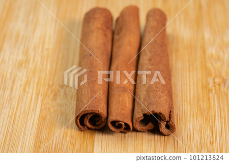 Cinnamon sticks on a wooden background. Fragrant cinnamon seasoning close-up. Spices with cinnamon. Food cooking video concept. ingredients for warm wine, mulled wine 101213824
