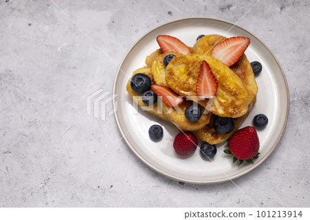 Flatly French Toast, Spanish Torrijas Made Of Sliced Baguette, Bread, Served With Orange Topping, Glaze, Fresh Blueberries, Strawberry On Granite Table. Copy Space For Text. Horizontal plane. Flatly French Toast, Spanish Torrijas Made Of Sliced Baguette, Bread, Served With Orange Topping, Glaze, Fresh Blueberries, Strawberry On Granite Table. Copy Space For Text. Horizontal plane. 101213914