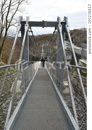 Vertical back view of people walking on the Titan RT giant suspension bridge in the Harz Mountains 101216817