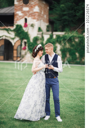 Bride and groom holding glasses with champagne and clink 101216874