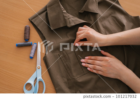 Top view of tailors workplace. Tailors hands preparing for sewing shirt 101217032