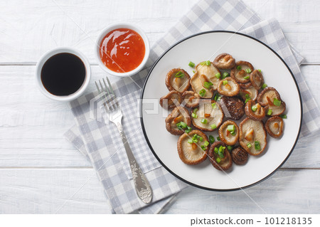 Stir-fried shiitake mushrooms with green onions closeup and spicy sauces. Horizontal top view Stir-fried shiitake mushrooms with green onions closeup and spicy sauces. Horizontal top view 101218135