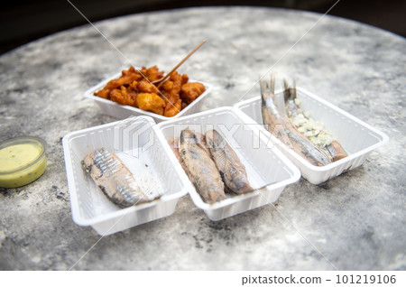 Food from a fish restaurant in Holland. Herring with onions. Battered fish in a container Food from a fish restaurant in Holland. Herring with onions. Battered fish in a container 101219106