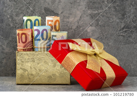 Accurately rolled up Euro banknotes in a gift box with golden bow Accurately rolled up Euro banknotes in a gift box with golden bow 101219780