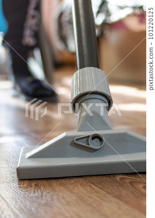 Vacuum cleaner brush on wooden floor closeup Vacuum cleaner brush on wooden floor closeup 101220125