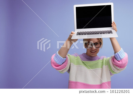 nice blond woman freelancer with a laptop in her hands shows a screen mockup on a purple background 101220201