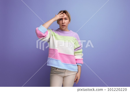 sad blonde young woman holding her head on purple background with copy space sad blonde young woman holding her head on purple background with copy space 101220220