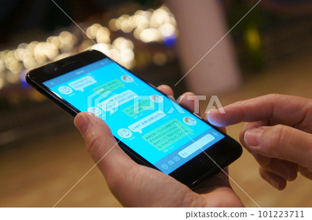 A woman who uses SNS at a meeting street corner A woman who uses SNS at a meeting street corner 101223711