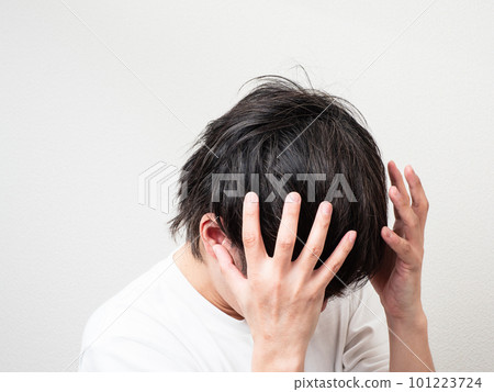 man holding his head with both hands man holding his head with both hands 101223724