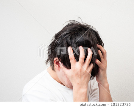 man holding his head with both hands man holding his head with both hands 101223725