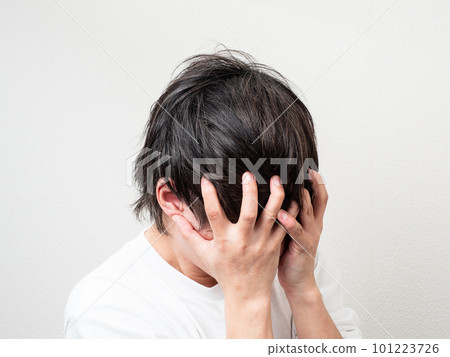 man holding his head with both hands man holding his head with both hands 101223726