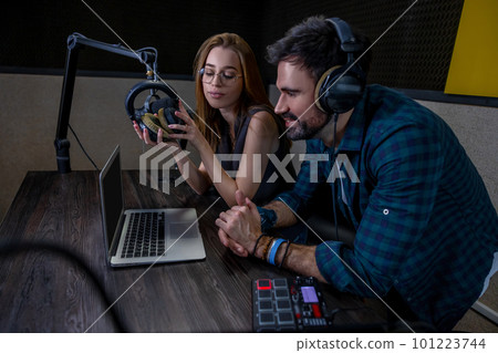 Two people sitting at the table and watching something on laptop 101223744