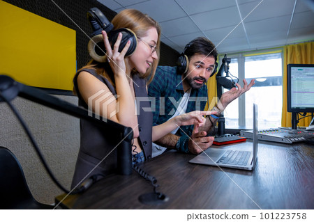 Two team members having a sound check and looking involved Two team members having a sound check and looking involved 101223758