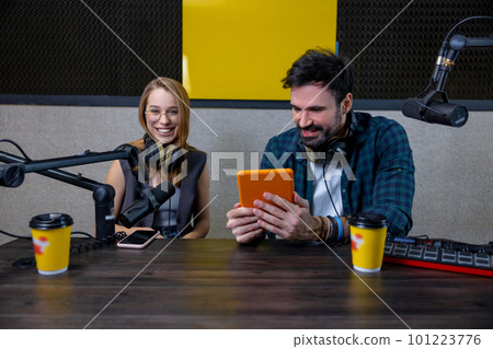 Two people at the studio preparing a radio program 101223776