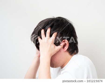 man holding his head with both hands man holding his head with both hands 101223874
