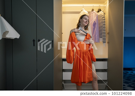 Difficult choice. A pretty woman who is trying to choose an item of clothing to wear from her wardrobe. Difficult choice. A pretty woman who is trying to choose an item of clothing to wear from her wardrobe. 101224098