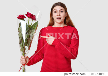 Surprised beautiful woman with cheerful expression, dark eyebrows, points at beautiful bouquet of roses, wonders recieving present from boyfiend, isolated over white background. Look at my flowers Surprised beautiful woman with cheerful expression, dark eyebrows, points at beautiful bouquet of roses, wonders recieving present from boyfiend, isolated over white background. Look at my flowers 101224099