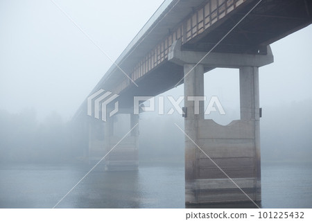 Bridge in fog, concrete bridge through river, bridgework between two banks of river, foggy sky, early morning. 101225432