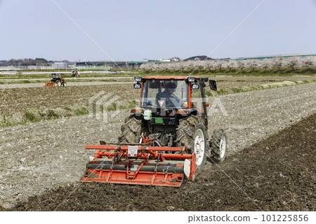 Take a picture of the landscape of the field being cultivated with a tractor 101225856