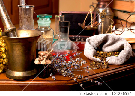 mortar and pestle near potions on wooden table. Close up of healing herbs alchemist stuff. Old pharmacy, alternative medicine concept. Dried healing herbs, flowers and candles, ritual purification , 101226554