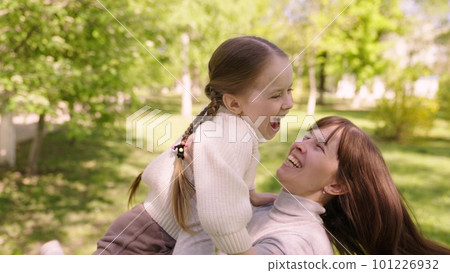 happy family. mom hugs child girl daughter park. cheerful girl spinning her mother arms. happy child. child dream mom. kid laughs his mother arms park. happy family concept. child runs green grass happy family. mom hugs child girl daughter park. cheerful girl spinning her mother arms. happy child. child dream mom. kid laughs his mother arms park. happy family concept. child runs green grass 101226932