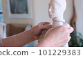 a sculpture girl polishes a limestone statue with sandpaper in a 101229383