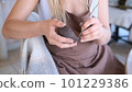 a woman processes a clay bowl with tools. 101229386