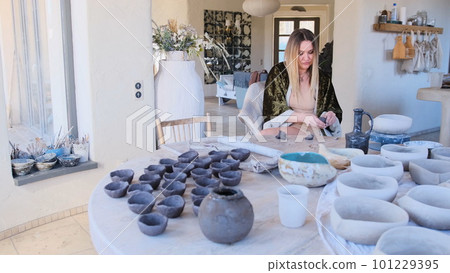a female ceramist sculpts pottery. 101229395