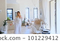 A joyful young woman is dancing in a bright modern living room 101229412