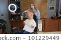 a man with disabilities gets his hair cut and styled in a barber shop. 101229449