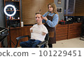 a man with disabilities gets his hair cut and styled in a barber shop. 101229451