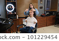 a man with disabilities gets his hair cut and styled in a barber shop. 101229454