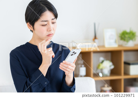 A young woman worried about her smartphone A young woman worried about her smartphone 101229971