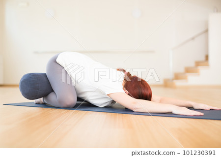 pregnant woman is engaged in yoga. Children asana with knees apart or Balasana pregnant woman is engaged in yoga. Children asana with knees apart or Balasana 101230391