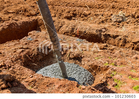 As workers pour concrete for foundation of building using an automatic pump is being directed As workers pour concrete for foundation of building using an automatic pump is being directed 101230603