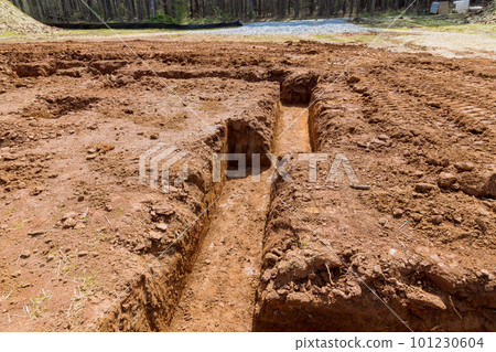 Building cement strip foundation fornew home digging trenches for pouring concrete under structure during construction 101230604