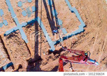 Foundation of house is constructed by pouring concrete strips using an automatic pump in order to direct cement concrete into foundations. Foundation of house is constructed by pouring concrete strips using an automatic pump in order to direct cement concrete into foundations. 101230634