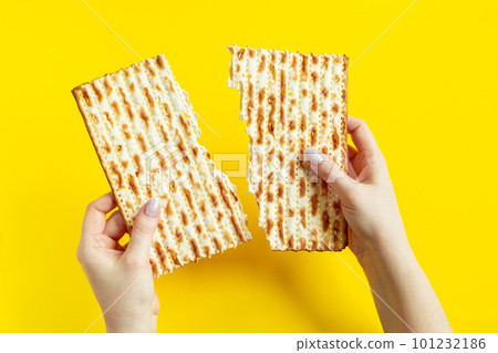 Woman is holding matzah. Celebrating the traditional Jewish holiday of Passover or Pesach. Matzo on yellow background. Woman is holding matzah. Celebrating the traditional Jewish holiday of Passover or Pesach. Matzo on yellow background. 101232186