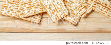 Background for the traditional Jewish holiday Pesach. Passover matzo bread on wooden table. Matzoh frame. Place for your text, banner format. Background for the traditional Jewish holiday Pesach. Passover matzo bread on wooden table. Matzoh frame. Place for your text, banner format. 101232202
