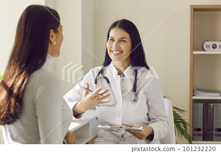 Doctor holding report file with appointment and giving consultation to a woman patient. Doctor holding report file with appointment and giving consultation to a woman patient. 101232220