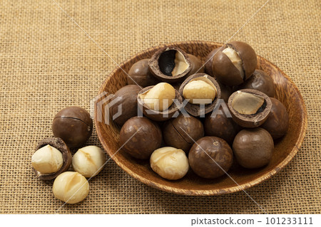 亞麻布上木盤中帶殼的澳洲堅果 101233111